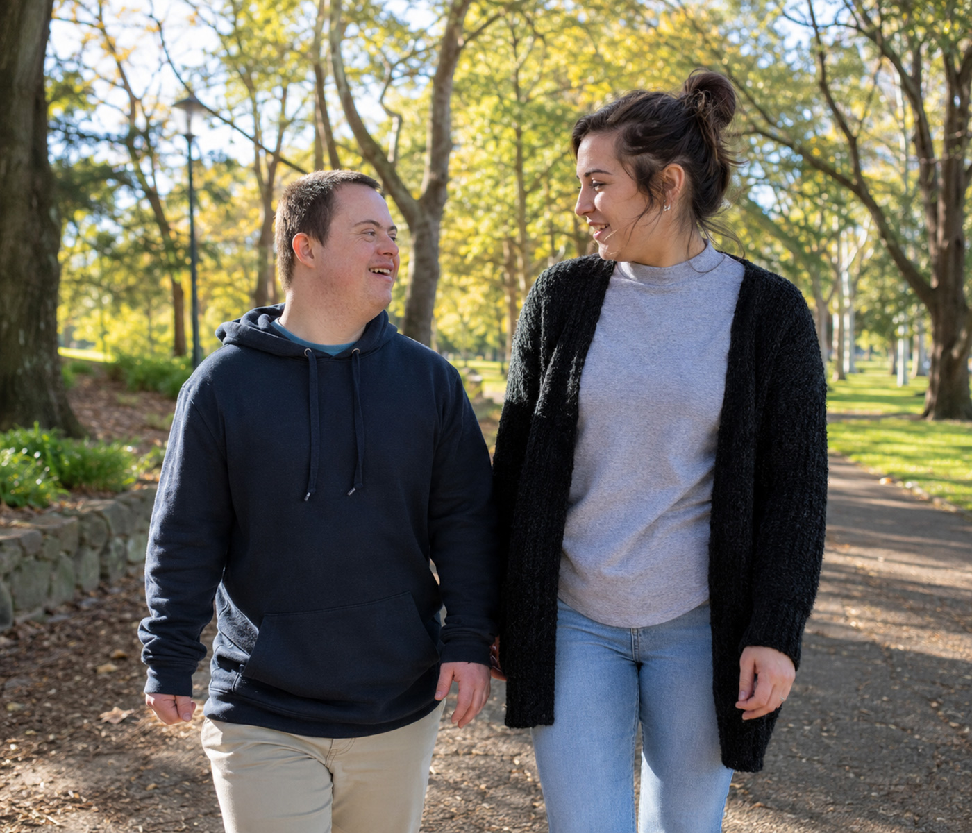 Divine Path Care support worker walking and having a friendly conversation with an NDIS participant in a green park